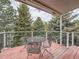 Outdoor deck with patio seating, offering a peaceful view of mature trees and sky at 19098 E Ida Dr, Aurora, CO 80015