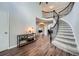 Grand entryway featuring a curved staircase with iron railings and hardwood flooring throughout the space at 19098 E Ida Dr, Aurora, CO 80015
