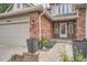 Brick facade and two-car garage with meticulously manicured landscape at 19098 E Ida Dr, Aurora, CO 80015