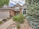 Charming two-story home with brick accents and a beautifully landscaped front yard with stone walkway at 19098 E Ida Dr, Aurora, CO 80015