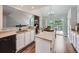 Open kitchen with white cabinets, an island, stainless appliances, and a view of the brick fireplace and deck at 19098 E Ida Dr, Aurora, CO 80015