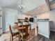 Eat-in kitchen featuring white cabinets, an island, stainless steel appliances, and a wooden dining table set at 19098 E Ida Dr, Aurora, CO 80015