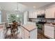 Bright kitchen with white cabinets, stainless steel appliances, an island, and a dining area with a slider to the deck at 19098 E Ida Dr, Aurora, CO 80015
