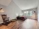 Spacious main bedroom with wood floors, vaulted ceiling, and a seating area with a rocking chair at 19098 E Ida Dr, Aurora, CO 80015
