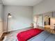 Bright main bedroom with wood floors, red throw blanket, and views to the arched doorway at 19098 E Ida Dr, Aurora, CO 80015