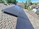 Close up of solar panels installed on a roof with asphalt shingles offering sustainability and energy efficiency at 19098 E Ida Dr, Aurora, CO 80015