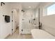 Bright bathroom showcases a glass-enclosed shower with a rainfall showerhead and built-in bench, next to a modern tub at 2060 Eliot St, Denver, CO 80211