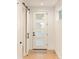Bright foyer featuring white walls, wood floors, and a modern door with glass panes at 2060 Eliot St, Denver, CO 80211