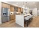 Open-concept kitchen boasts stainless steel appliances, a quartz waterfall island, and modern pendant lighting at 2060 Eliot St, Denver, CO 80211