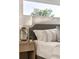Close-up of the main bedroom showcasing a stylish nightstand, lamp, and upholstered headboard with nailhead trim at 2060 Eliot St, Denver, CO 80211