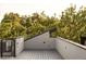 An outdoor deck area is surrounded by a wall and foliage is visible in the background at 2060 Eliot St, Denver, CO 80211