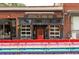 Exterior view of Jefferson Park Pub, showcasing a red door, flower boxes and rainbow barriers at 2060 Eliot St, Denver, CO 80211