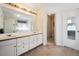 Bathroom with double sinks, large mirror with Hollywood lights and gold-framed glass shower at 13362 Marion St, Thornton, CO 80241