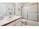 Bright bathroom with vanity, sink, and tub with glass doors at 13362 Marion St, Thornton, CO 80241
