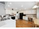 Bright kitchen features white cabinets, hardwood floors, and modern appliances at 13362 Marion St, Thornton, CO 80241
