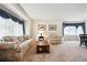 Cozy living room with floral sofa, area rug, and natural light from large windows at 13362 Marion St, Thornton, CO 80241