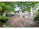 View of home's backyard with newly exposed soil, mature trees and deck at 204 Maple St, Frederick, CO 80530