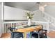 Elegant dining table with seating for four, set against a backdrop of neutral walls and staircase at 204 Maple St, Frederick, CO 80530