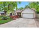 Charming brick home featuring a ramp, well-manicured lawn, and two-car garage at 204 Maple St, Frederick, CO 80530