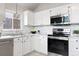 Modern kitchen featuring white cabinets, a stainless steel oven and microwave, and a stylish backsplash at 204 Maple St, Frederick, CO 80530