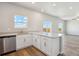 Bright, open kitchen with a large island, stainless steel dishwasher, and views of the outdoors at 48230 Shetland Dr, Bennett, CO 80102