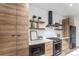 Modern kitchen with wood cabinets, stainless steel appliances, and floating shelves at 3580 W 62Nd Pl, Denver, CO 80221