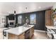 Modern kitchen with island, sink, dishwasher and view into living room at 3580 W 62Nd Pl, Denver, CO 80221