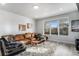 Relaxing living room with leather couch, coffee table, and large window at 3580 W 62Nd Pl, Denver, CO 80221