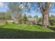 A large backyard features a lush lawn, mature trees, and a wooden fence perfect for enjoying outdoor activities at 6882 Moore St, Arvada, CO 80004