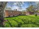 Brick house with large backyard, lawn, landscaping, and mature trees at 6882 Moore St, Arvada, CO 80004