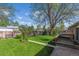 A spacious backyard features a lush lawn, mature trees, wooden fence, and concrete patio perfect for outdoor entertaining at 6882 Moore St, Arvada, CO 80004