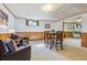 Finished basement featuring carpet, wood paneling, furniture and bar seating at 6882 Moore St, Arvada, CO 80004