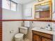 Bathroom features a vanity, toilet, decorative mirror, and framed art at 6882 Moore St, Arvada, CO 80004