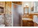 A bathroom with wood cabinets, tile, and shower with translucent doors at 6882 Moore St, Arvada, CO 80004