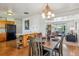 Open-concept view of dining room with wood table and chairs flowing into living area at 6882 Moore St, Arvada, CO 80004