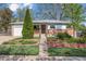 Charming single-story home featuring a brick facade, well-kept lawn and mature trees at 6882 Moore St, Arvada, CO 80004