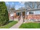 Charming single-story home featuring a brick facade, well-kept lawn and mature trees at 6882 Moore St, Arvada, CO 80004