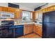 Kitchen with wood cabinets, black appliances, and natural light from window at 6882 Moore St, Arvada, CO 80004