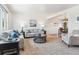 Open-concept living room with neutral walls, plush seating, and an adjacent dining area at 6882 Moore St, Arvada, CO 80004