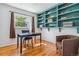 Home office featuring hardwood floors, a large window, and built-in turquoise shelving at 6882 Moore St, Arvada, CO 80004