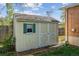 A charming storage shed with a white door and green trim provides extra space for your gardening and outdoor equipment at 6882 Moore St, Arvada, CO 80004