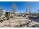 A large backyard with a stone patio and an array of furniture and storage space at 7310 Carnation Pl, Commerce City, CO 80022