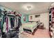 A bedroom featuring a double bed, side table, full closet and wood laminate flooring at 7310 Carnation Pl, Commerce City, CO 80022