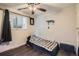 Cozy bedroom features a ceiling fan, wood floors, and a window for natural light at 7310 Carnation Pl, Commerce City, CO 80022