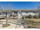 Inviting single story home featuring stone accents, front porch seating, and a well-manicured front yard at 7310 Carnation Pl, Commerce City, CO 80022