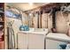 This laundry room includes a washer, dryer, deep freezer, and utility sink with exposed ductwork at 7310 Carnation Pl, Commerce City, CO 80022