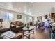 Spacious open-concept living and dining area featuring dark laminate flooring and elegant leather furniture at 7310 Carnation Pl, Commerce City, CO 80022