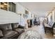 Spacious living room with leather sofa, coffee table, and several windows providing natural light at 7310 Carnation Pl, Commerce City, CO 80022