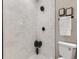 Shower with white subway tile, black fixtures, and mosaic tile floor at 3120 N Race St, Denver, CO 80205