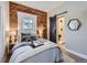 Bedroom with an exposed brick wall, barn door to bathroom, and decorative accents at 3120 N Race St, Denver, CO 80205